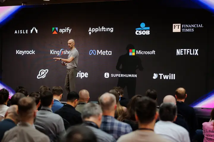 Speaker on the ELC main stage in front of the company logo wall